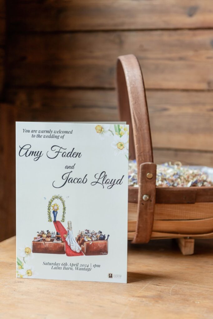 A wedding invitation for Amy and Jacob propped against a wooden chair with a rustic backdrop.